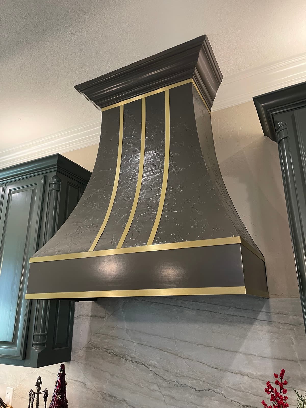 Custom dark range hood with gold accents